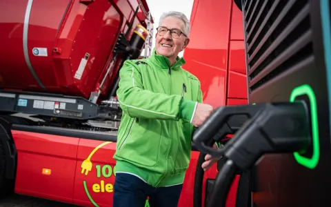 man staat elektrische vrachtwagen op te laden 